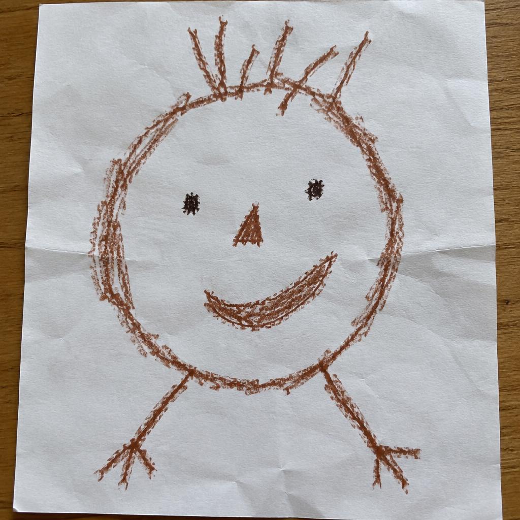 A basic beginner's crayon drawing of a face: circle head, dot eyes, triangle nose and a big smile